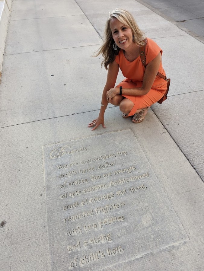 Paige Riehl’s poem Dragonfly stamped in a sidewalk, close-up view